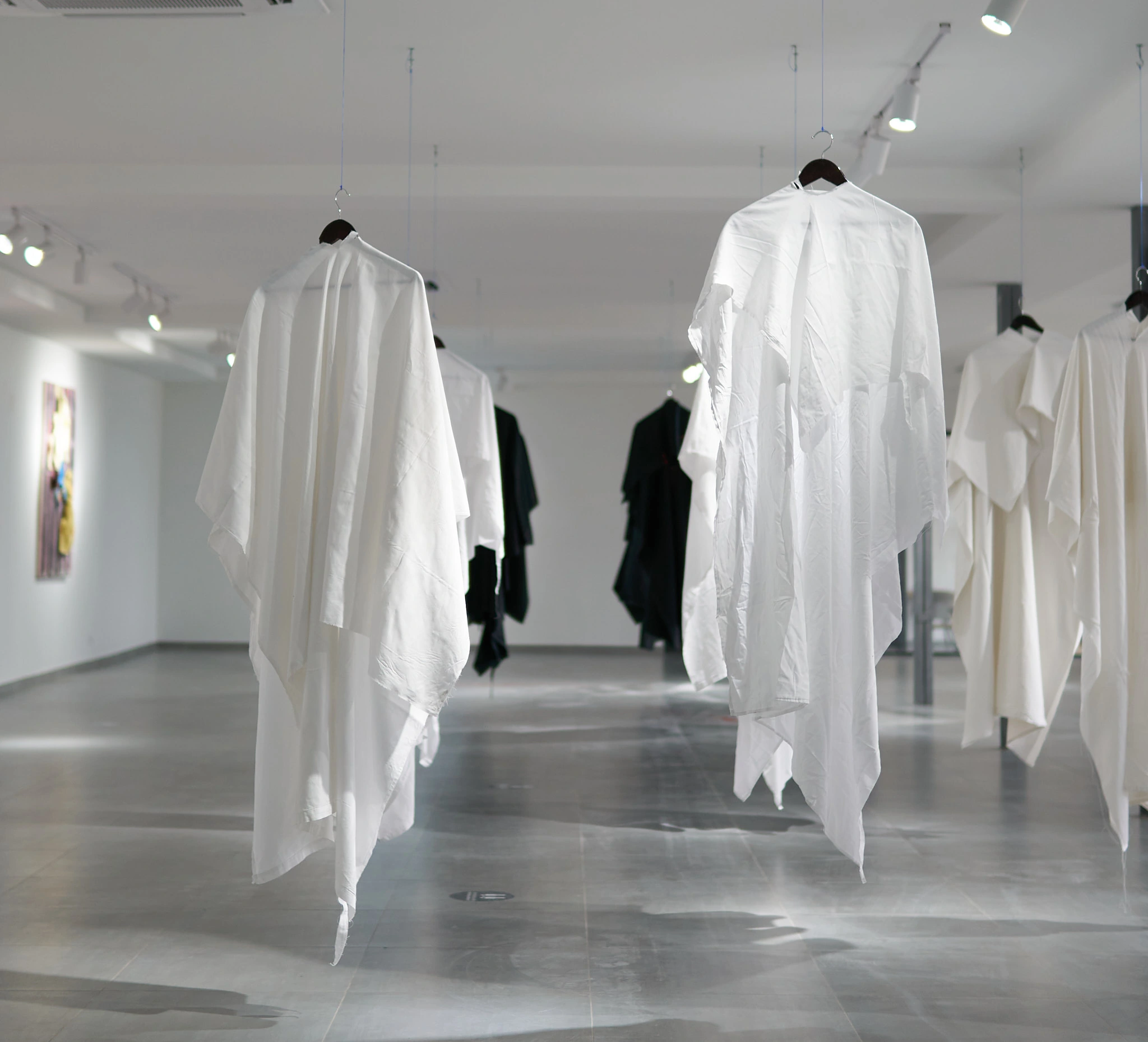 White and black garments suspended in the gallery at Gela Mikava’s 2022 Ria Keburia Foundation exhibition